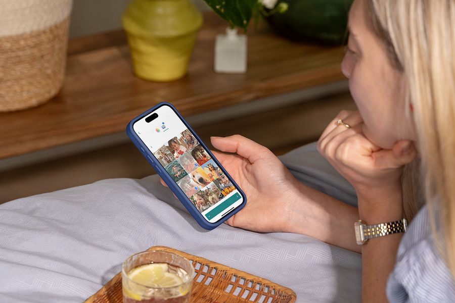 Eine Frau wählt Fotos auf ihrem Smartphone-Bildschirm für ihr Jahrbuchprojekt aus und organisiert sie.
