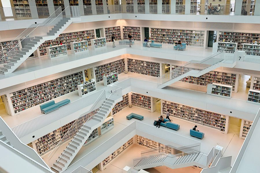 Die Stadtbibliothek Stuttgart in Deutschland, ein futuristisches weißes Atrium mit minimalistischem Design, ein modernes Highlight für Architekturfans und Literaturreisen mit posterXXL.