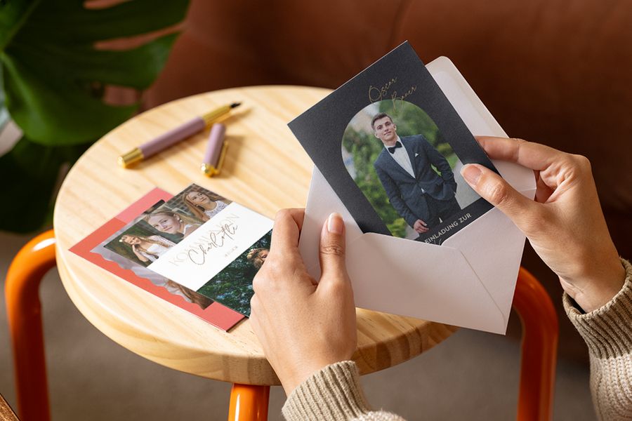 Eine Person betrachtet personalisierte Einladungen zur Konfirmation und Glückwunschkarten zur Vorbereitung auf die Konfirmation mit posterXXL.