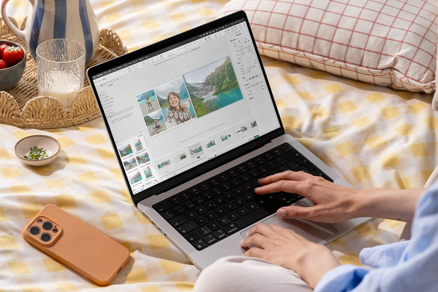Jemand nutzt den posterXXL Fotobuch-Editor mit einem Laptop im Bett – als Inspiration für ein Fotobuch einfach online erstellen und ein schnelles Fotobuch.