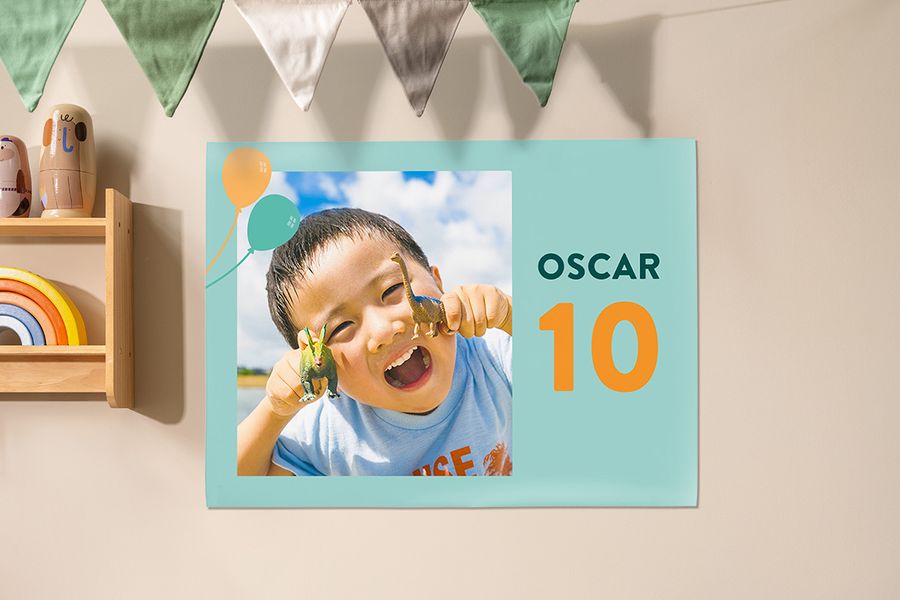 Ein personalisiertes posterXXL Poster als Dekoration auf einer Kinderparty, mit einem Jungen, der Dinosaurier hält, um seinen 10. Geburtstag zu feiern – als Inspiration für Kinderparty Deko und Kinderparty Ideen.