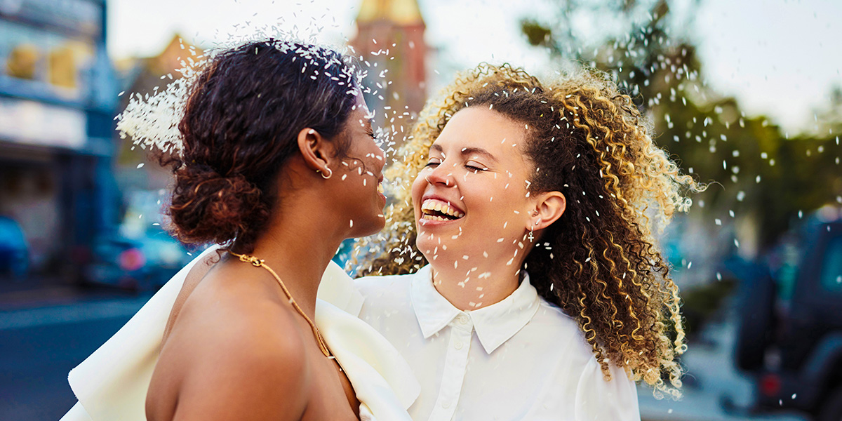 Ein lächelndes Brautpaar an seinem Hochzeitstag – als Inspiration für was man in eine Hochzeitskarte schreibt und passende Glückwünsche zur Hochzeit.