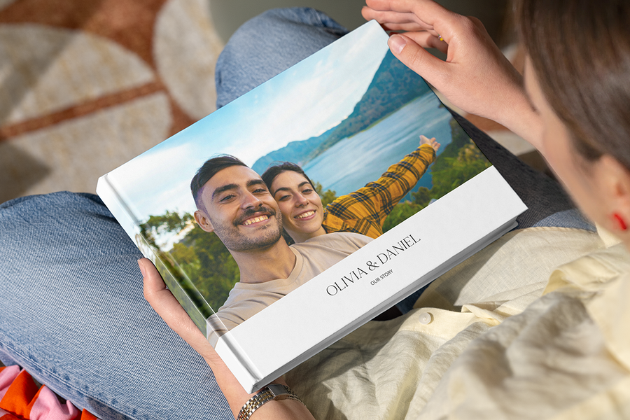 Ein personalisiertes posterXXL Fotobuch mit einem glücklichen Paar an einem malerischen Ort auf dem Cover, das eine Fotobuch-Überraschung als romantische Idee für einen Heiratsantrag zeigt.