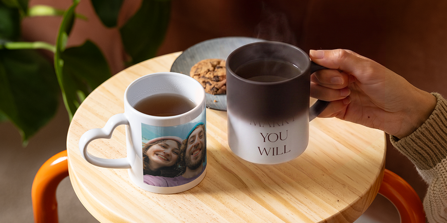 Eine personalisierte, wärmeempfindliche posterXXL Tasse zeigt nach und nach die Worte „Willst du mich heiraten?“, als kreative und romantische Idee für einen Heiratsantrag.