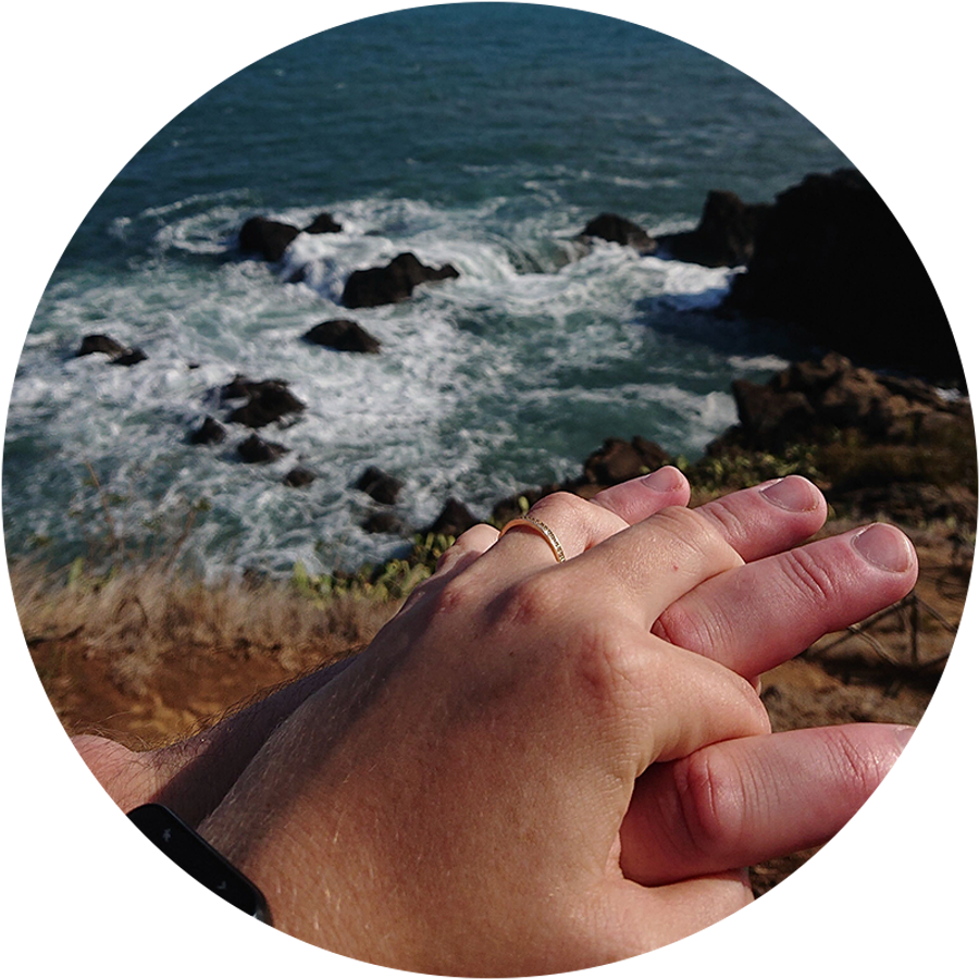 Zwei Hände, die sich am Meer auf Madeira halten, eine davon mit Verlobungsring, zeigen Kamillas romantische Urlaubs-Geschichte ihres Heiratsantrags.