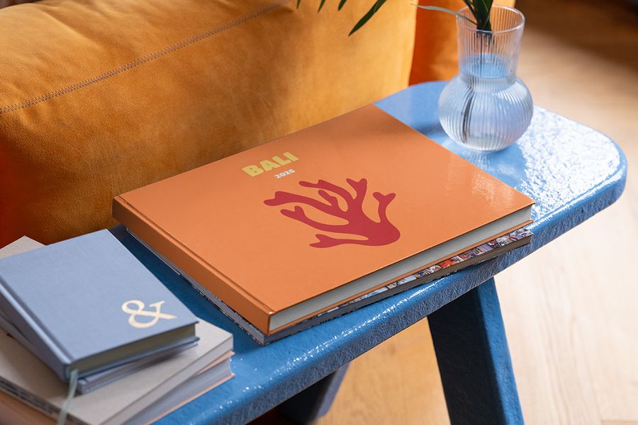 Ein personalisiertes posterXXL Reise-Fotobuch im Querformat über Bali liegt auf einem blauen Couchtisch – als Inspiration für sommerliche Couchtisch-Deko und die letzten Details deiner Sommerdeko.