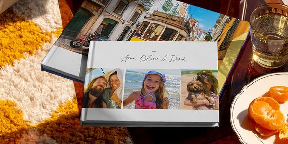 Zwei verschiedene posterXXL Reise-Fotobücher sind zusammen zu sehen, darunter ein Urlaubsfotobuch im Querformat mit Familienreisefotos auf dem Cover und ein weiteres mit einer Straßenbahn im Urlaubsmotiv – als Inspiration für verschiedene Reise-Fotobuch-Ideen.