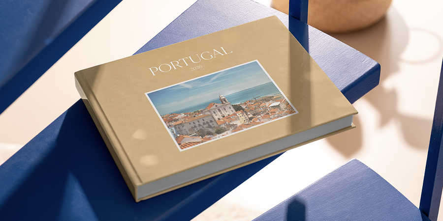 Ein personalisiertes posterXXL Familienfotobuch mit dem Titel Portugal 2026 liegt auf einem Tisch und hält Erinnerungen an den Familienurlaub als schöne Erinnerung an die Reise fest.