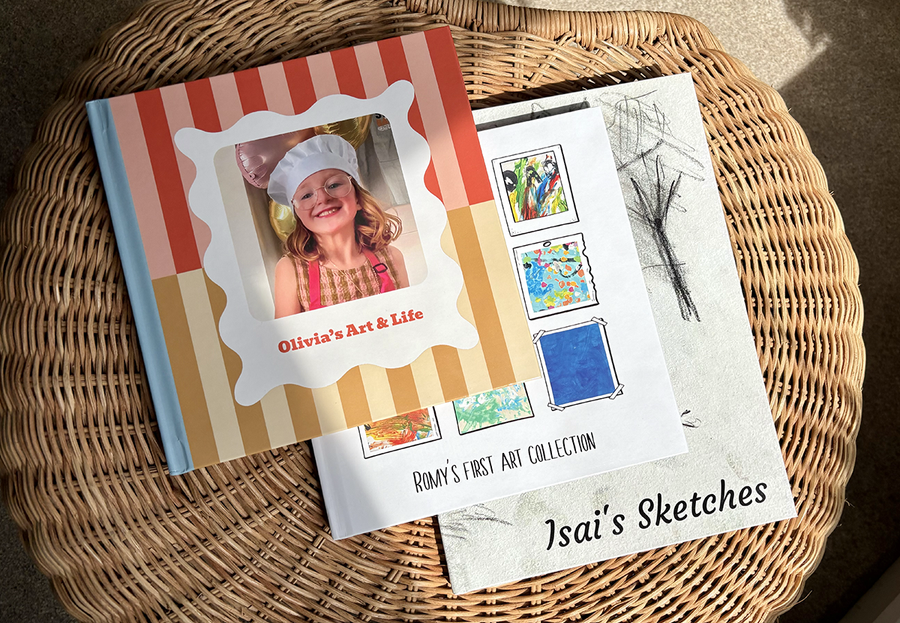 Drei Kinderfotobücher liegen gestapelt auf einem Couchtisch, jedes mit Kunstwerken einer anderen Altersgruppe, von Gemälden kleiner Kinder bis zu Skizzen von Teenagern, und zeigen die Vorteile eines posterXXL Kinderfotobuchs.