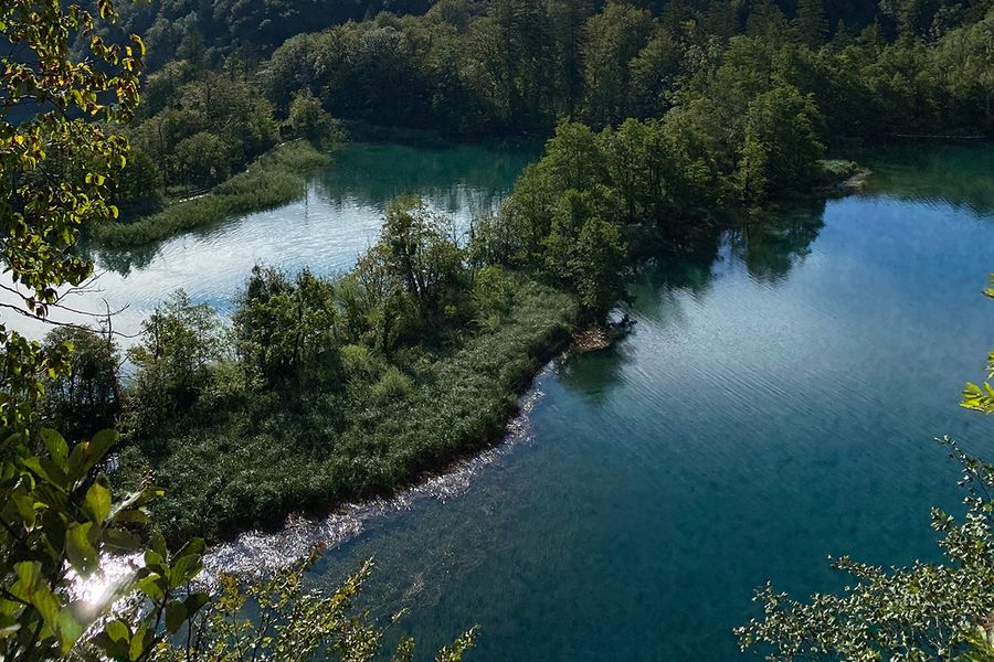 Kaskadenartige smaragdgrüne Wasserfälle und Holzstege über türkisfarbenem Wasser im Nationalpark Plitvicer Seen in Kroatien, einer der schönsten Nationalparks Europas in posterXXLs Ratgeber.