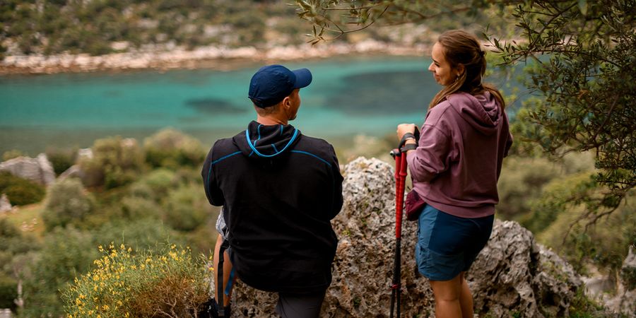 Ein Paar steht in einem wunderschönen Nationalpark und blickt auf einen blauen See, und fängt die Naturschönheit in posterXXLs Ratgeber zu den schönsten Nationalparks Europas ein.