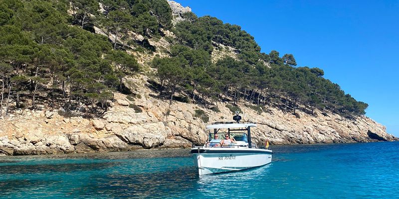 Gemma, Texterin bei posterXXL, sitzt in einem Boot vor der Küste von Ibiza und stellt ihre liebsten September-Urlaubsziele in Europa vor.