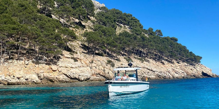 Gemma, Texterin bei posterXXL, sitzt in einem Boot vor der Küste von Ibiza und stellt ihre liebsten September-Urlaubsziele in Europa vor.