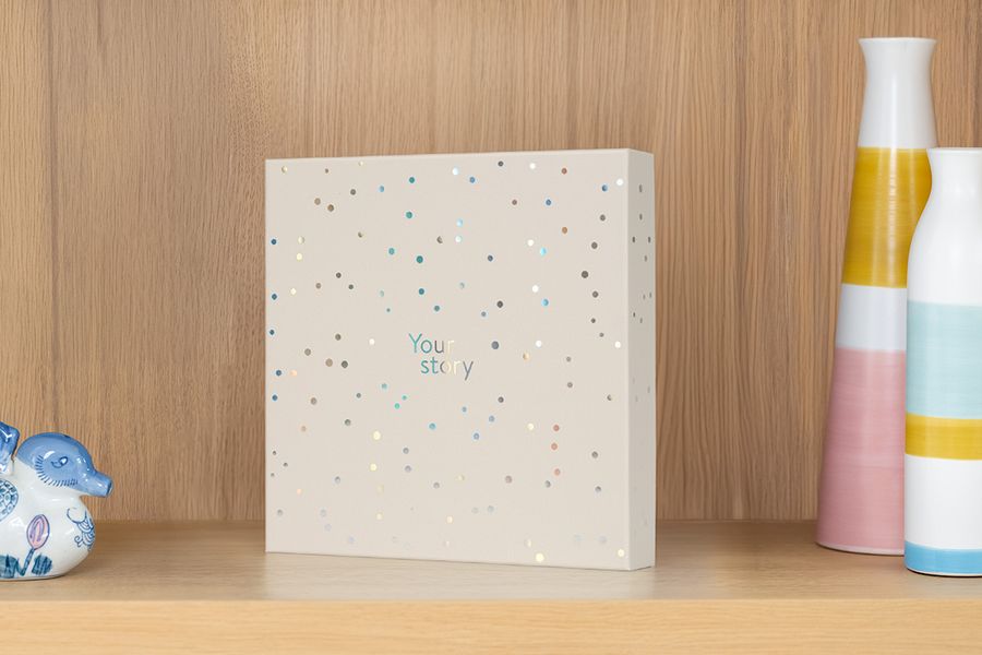 Die Präsentationsbox steht auf einem Regal neben einer Vase und Dekorationsgegenständen, und veranschaulicht, wie sie auch als attraktive Aufbewahrungsbox für Fotoalben dient.