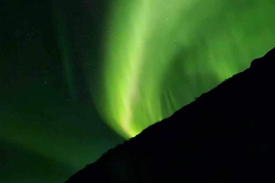 Polarlichter am Himmel in sehr intensiven Grüntönen, zur Illustration von posterXXLs Kompositionstipps für das Fotografieren der Polarlichter.