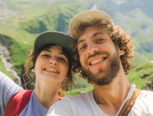 Ein lächelndes Paar in einer malerischen Hügellandschaft bei einem Sommerabenteuer, ideal für Sommer-Bildunterschriften für Instagram oder ein posterXXL Fotobuch.