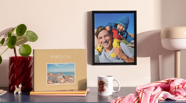 Sammlung personalisierter Fotoprodukte in einem Regal, darunter ein Fotobuch, ein gerahmtes Wandbild und eine Tasse.