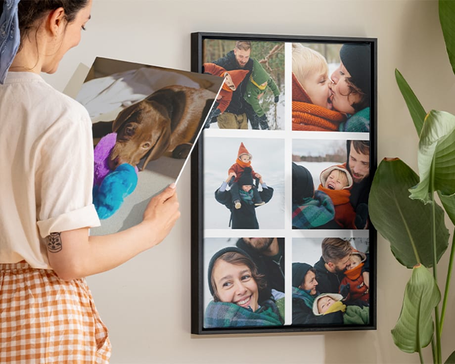 Eine lächelnde Frau, die ein Wandbild neben einer Leinwand hält.