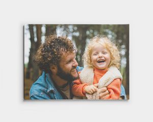 Foto auf Leinwand mit Vater und Kind, die im Wald lächeln