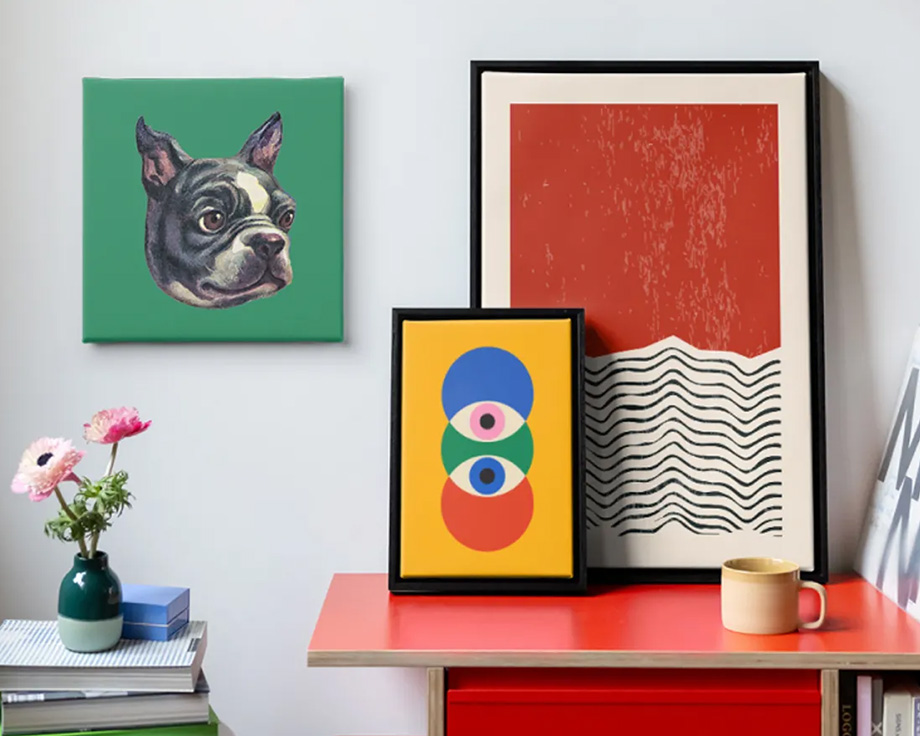 Drei abstrakte posterXXL Wandbilder neben einem Stapel Schallplatten in einem stilvollen modernen Wohnzimmer – als Inspiration für moderne Wanddeko-Ideen.