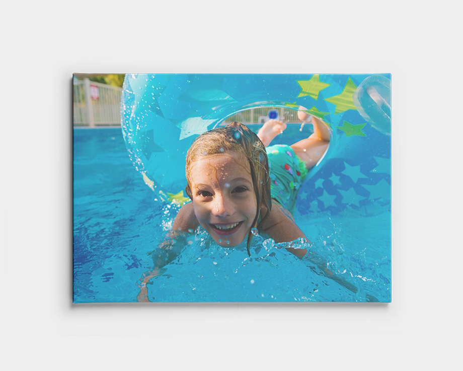 Foto auf Leinwand eines Kindes, das im Pool unter Wasser schwimmt.