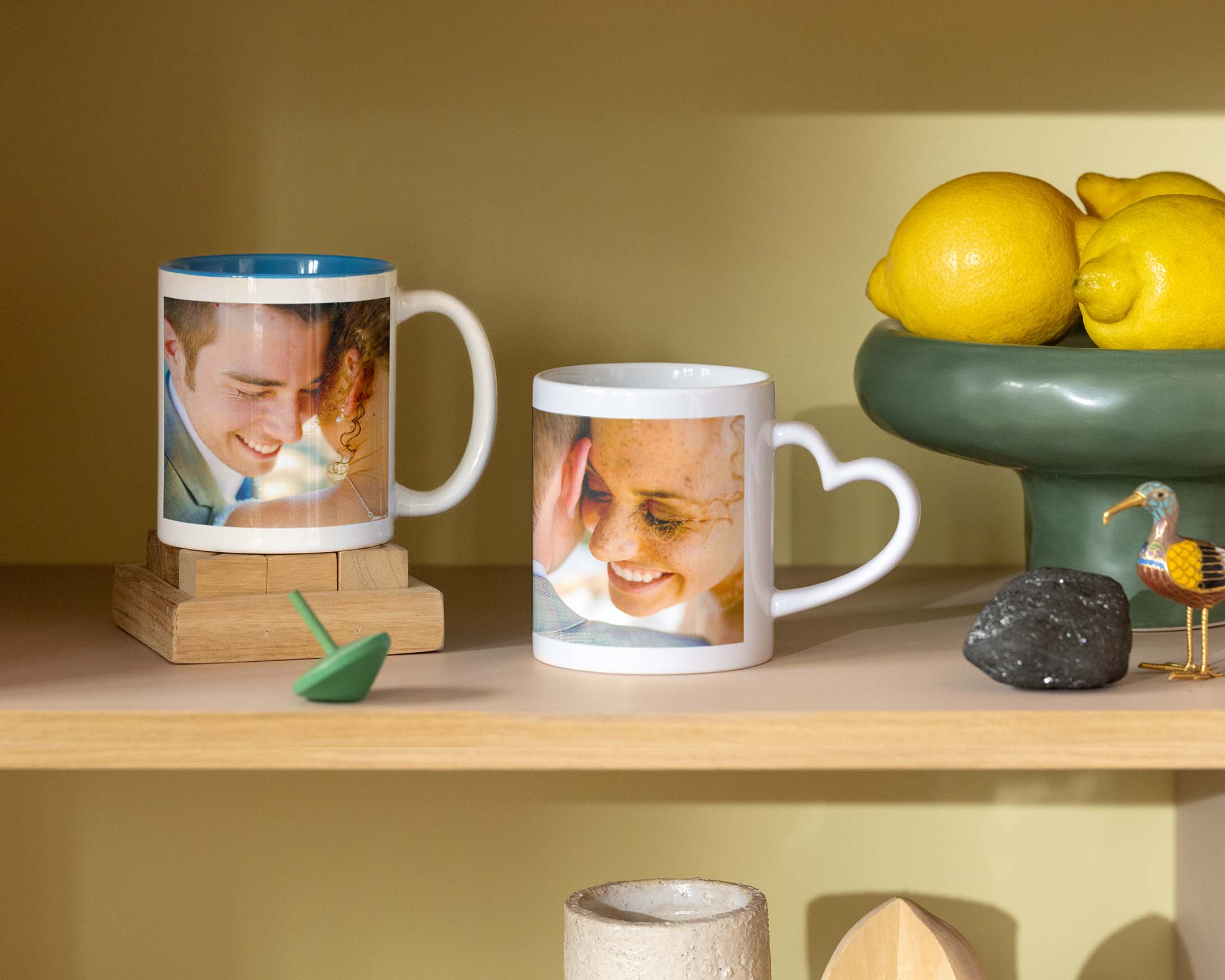 Zwei personalisierte Tassen mit Hochzeitsfotos, eine mit herzförmigem Griff.